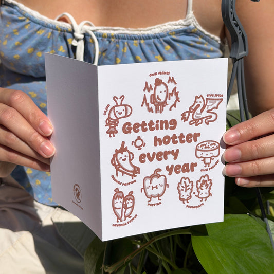 Person holding a birthday card that says getting hotter every year