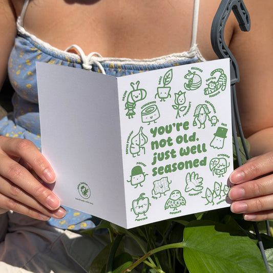 Person holding a birthday card saying youre not old, just well seasoned.