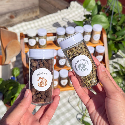 hands holding spice jars with labels all spice and herbes de provence