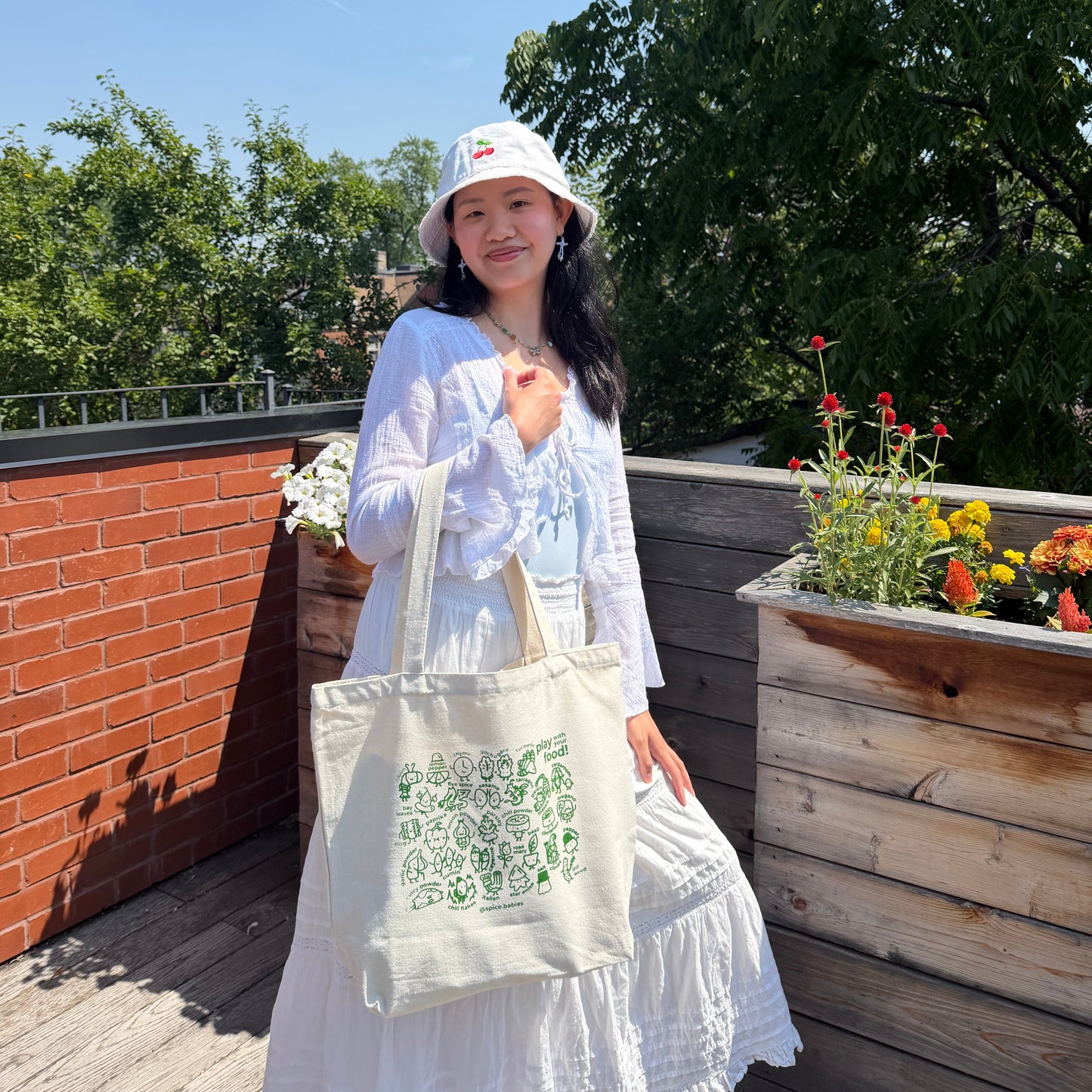Person holding a spice babies tote bag on their arm in the sun