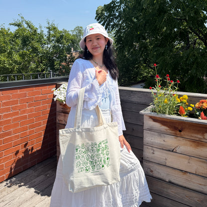Person holding a spice babies tote bag on their arm in the sun